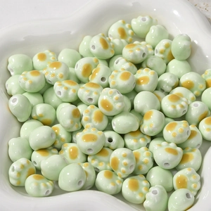 Macro detail of cat paw ceramic beads with orange pads in a white decorative bowl