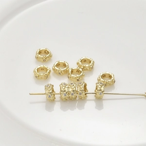 Detailed close-up of 14k gold-plated spacer beads with zircon inlays for DIY jewelry