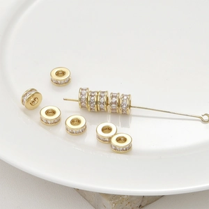Detailed macro view of 14k gold-plated spacer beads with zircon inlays for DIY jewelry