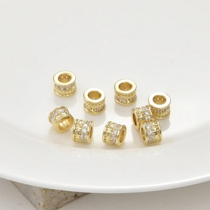 Macro shot of 14k gold-plated brass spacer beads with cubic zirconia and twisted texture