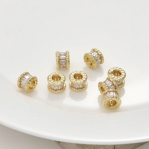 Macro detail of 14k gold-plated brass cylinder spacer beads with cubic zirconia inlay