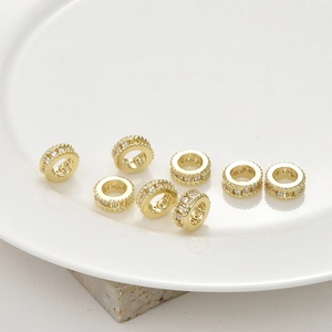 Macro detail of 14k gold-plated spacer beads with micro-pave zircon crystals for DIY jewelry