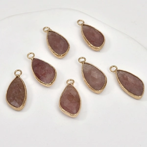 Detailed macro view of seven faceted teardrop crystal pendants with engraved gold plating