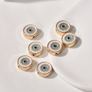 Detail von sieben goldenen Evil Eye-Anhängern mit blauem Emaille-Finish für DIY-Schmuckbau