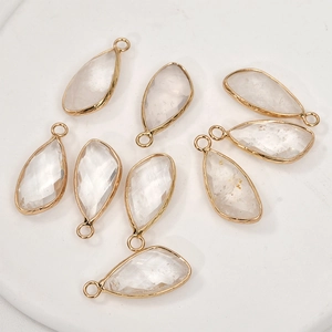 Detailed macro of gold plated faceted crystal teardrop charms for jewelry making