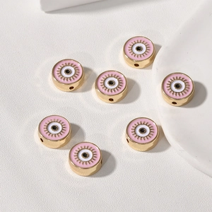 Makro-Detail von rosa Emaille-Perlen mit bösem Blick und Goldfinish für DIY-Schmuck