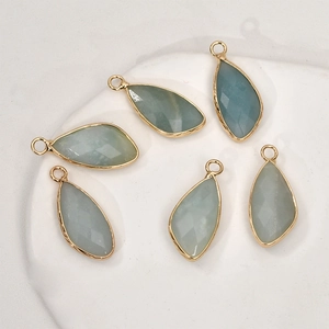 Detail of six light blue faceted teardrop pendants with gold plated copper edging