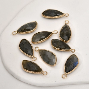 Macro shot of teardrop faceted labradite stones with gold-plated engraved metal frames