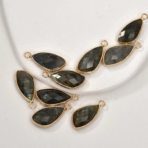 Macro shot of faceted teardrop labradorite stone charms with gold plated copper borders