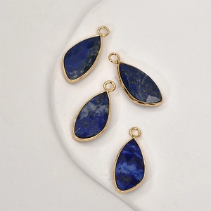 Detail of four teardrop lapis lazuli pendants with gold edges for DIY jewelry making