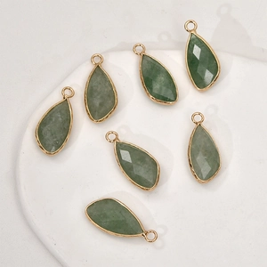 Macro shot of 7 green drop-shaped gemstones with gold plated edges for DIY jewelry making