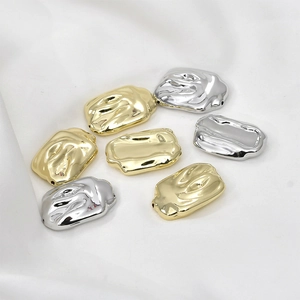Irregular textured gold and silver plated bar beads for DIY jewelry making on white fabric
