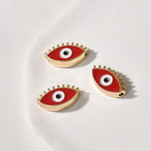 Detaillierte Makroansicht von drei roten Emaille-Bösen-Blick-Perlen mit goldenen Wimpern für DIY