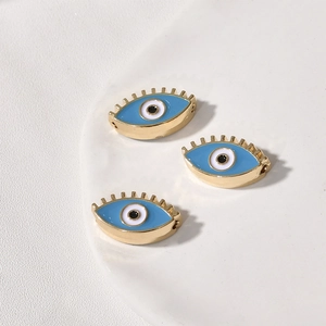 Drei vergoldete Evil-Eye-Perlen mit blauer Emaille für DIY-Schmuck in der Nahaufnahme