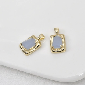 Détail de pendentifs rectangulaires en opale bleue avec sertissage à quatre griffes doré