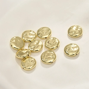 Dettaglio di perle barocche piatte placcate oro 14k con texture martellata per gioielli DIY