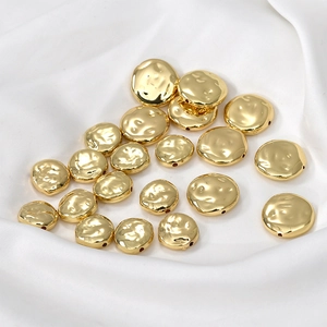 Dettaglio macro di perle piatte irregolari placcate in oro 14k per gioielli fai da te