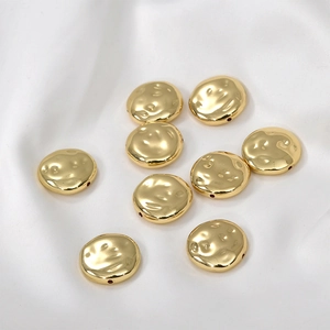Dettaglio macro di perline a disco martellato placcate oro 14k per la creazione di gioielli