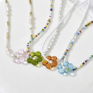 Handmade bead necklaces with colorful transparent glass flower pendants on white background