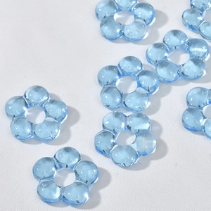 Macro detail of light blue transparent five-petal flower beads for DIY jewelry making