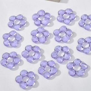 Macro view of purple transparent five-petal glass flower beads for DIY jewelry making