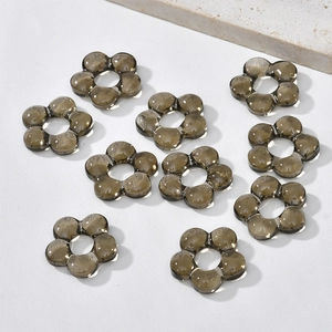 Detail of smoky gray glass flower beads with six petals for DIY jewelry making