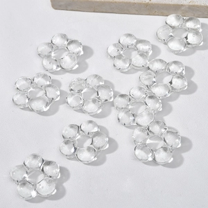 Close-up of transparent five-petal glass flower beads for DIY jewelry making with center hole