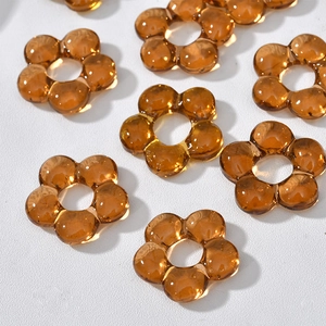 Close-up of amber hollow flower beads made of transparent resin for DIY jewelry crafting