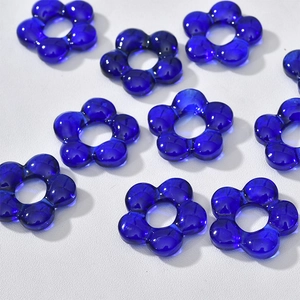 Close-up of translucent blue glass flower beads with center hole for DIY jewelry making