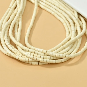 Détail de perles multicouches en turquoise synthétique blanc mat pour création de bijoux