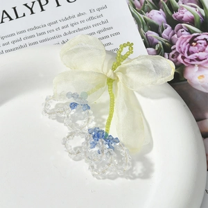 Detail of sweet chiffon bow with crystal flower beads on elegant ceramic tray