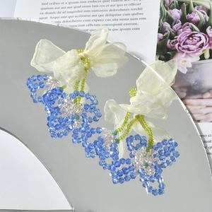 Detail of handmade chiffon bow earrings with blue and pink crystal beaded flower charms
