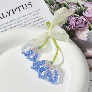 Chiffon bow hair tie with crystal flower charms on a decorative eucalyptus book background