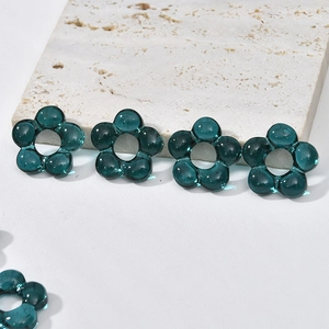 Close-up of translucent dark green hollow glass flower beads for DIY jewelry making