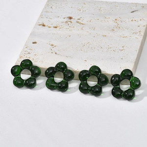 Macro shot of 4 emerald green glass flower beads for jewelry making with center hole