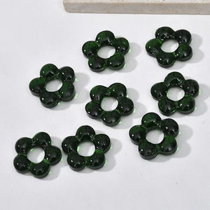 Detailed view of translucent dark green glass flower beads with center holes for jewelry DIY