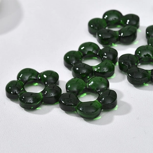 Macro shot of dark green transparent glass flower beads with center holes for jewelry DIY