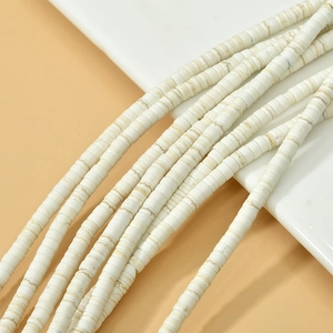 Gros plan de perles en turquoise blanche avec marbrures naturelles pour bijoux artisanaux