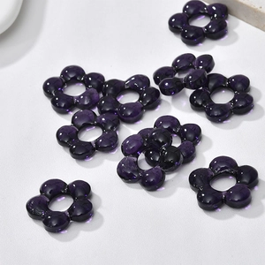 Close-up of translucent deep purple five-petal flower beads for DIY jewelry making