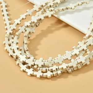 Gros plan de perles en croix turquoise blanche avec texture marbrée pour bijoux DIY