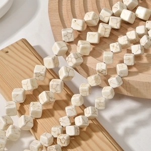 Détail de perles cubiques en turquoise blanche avec texture marbrée brune pour bijoux DIY