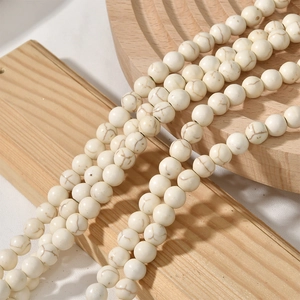 Détail macro de perles rondes en howlite blanche veinée pour la création de bijoux