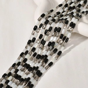 Detail von zylindrischen facettierten Glas- und Perlmuttperlen für DIY-Schmuck