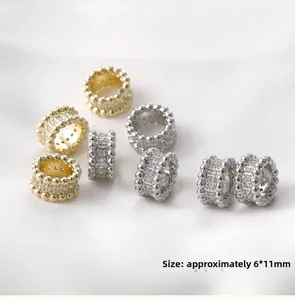 Detail of 14k gold plated cylinder charms with cubic zirconia and beaded edges 6x11mm