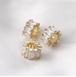 Close-up of three 14k gold-plated barrel beads with baguette-cut cubic zirconia stones