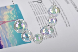 Nahaufnahme irisierender Glasperlen mit Aurora-Finish auf einem Magazin-Hintergrund