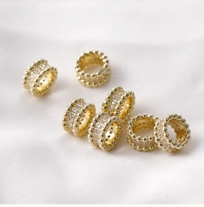 Macro detail of 14k gold plated barrel beads with sparkling micro-paved cubic zirconia