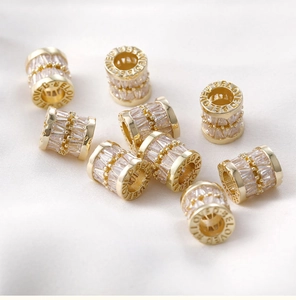 Macro shot of 14k gold plated barrel beads with pavé zircon and BELOVED engraving