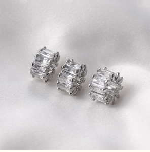 Macro shot of 14k gold-filled barrel beads with baguette-cut cubic zirconia insets