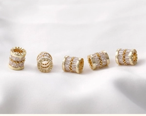 Detail of 14k gold-filled wheel bead with zircon inlay and 'BELOVED' engraving
